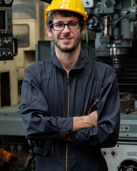 Young skillful factory worker or engineer close up portrait in factory